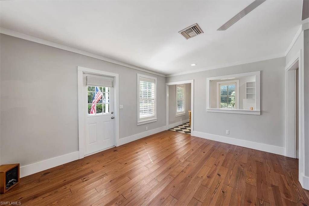 1984 Frederick Street Naples, FL 34112 - Photo 9 of 25 a view of an empty room with a window and wooden floor