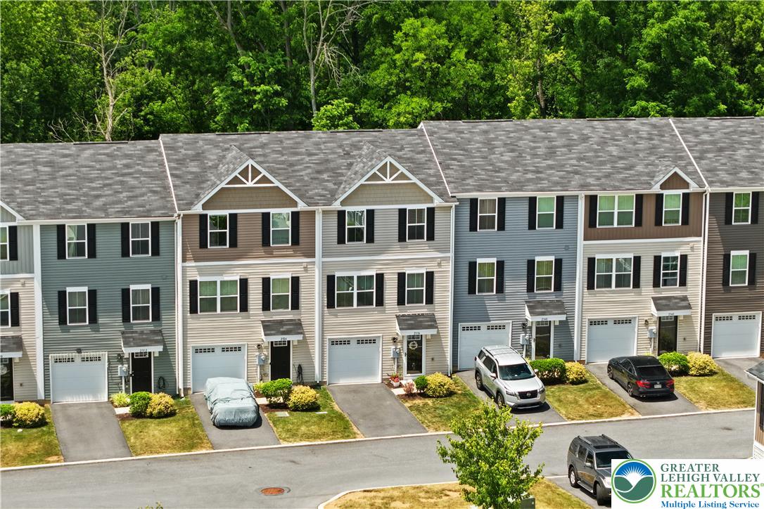 2336 Alex Road Easton, PA 18040 - Photo 30 of 35 Rows of well-maintained townhouses with individual garages line a verdant, tree-lined street.