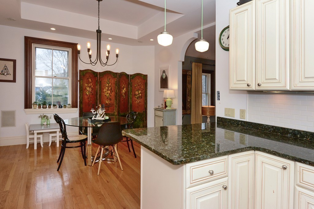 7 Winter Street, Unit 5 Salem, MA 01970 - Photo 15 of 41 a kitchen with stainless steel appliances granite countertop a stove a sink a dining table and chairs with wooden floor