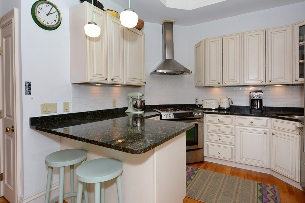 7 Winter Street, Unit 5 Salem, MA 01970 - Photo 20 of 41 a kitchen with stainless steel appliances granite countertop a sink a stove and white cabinets