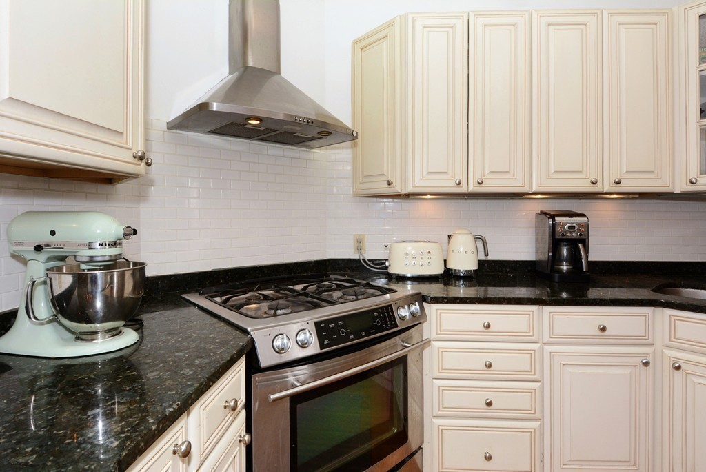 7 Winter Street, Unit 5 Salem, MA 01970 - Photo 21 of 41 a kitchen with granite countertop a stove a sink dishwasher and cabinets with wooden floor