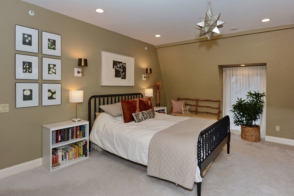 7 Winter Street, Unit 5 Salem, MA 01970 - Photo 24 of 41 a spacious bedroom with a bed a wall painting and a potted plant