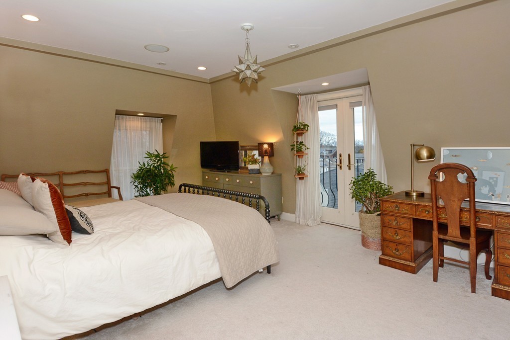7 Winter Street, Unit 5 Salem, MA 01970 - Photo 25 of 41 a spacious bedroom with a bed and a chandelier