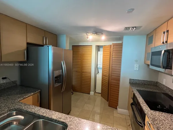 a kitchen with stainless steel appliances granite countertop a refrigerator and a stove