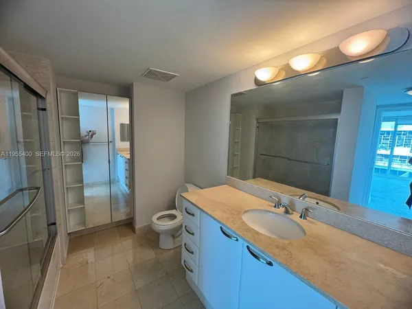 a bathroom with a granite countertop sink toilet and shower