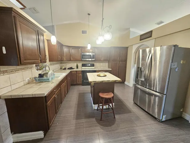 a kitchen with granite countertop a sink appliances and cabinets