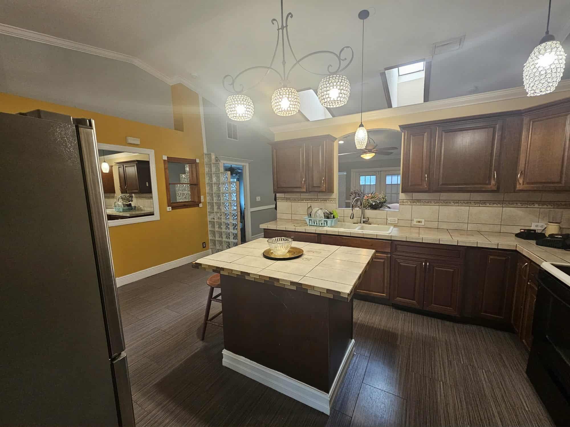 3641 Southwest Parsons Street Port St. Lucie, FL 34953 - Photo 7 of 11 a kitchen with kitchen island granite countertop wooden cabinets and refrigerator