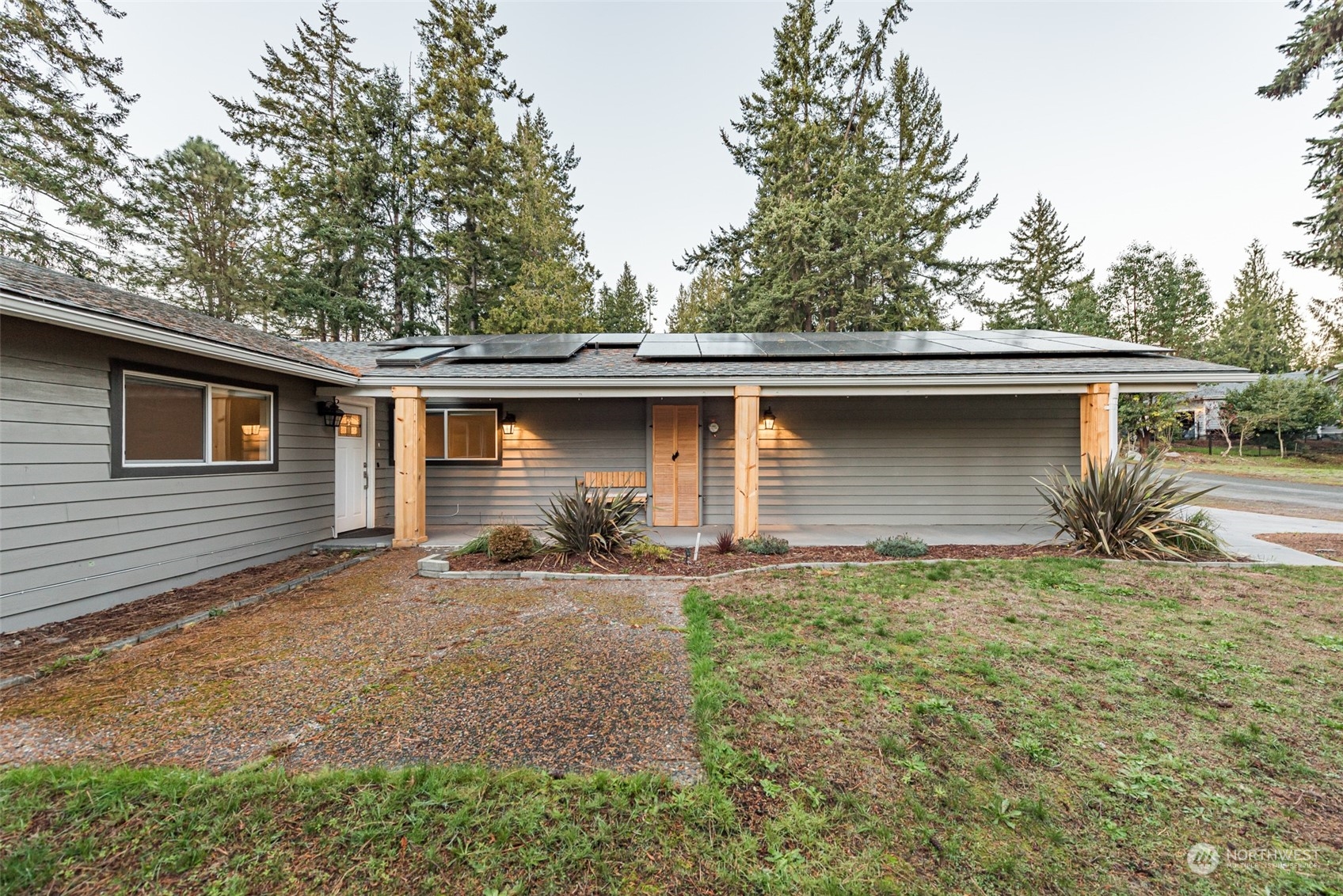 146 Sunset Place Sequim, WA 98382 - Photo 36 of 40 a backyard of a house with large trees and a barn