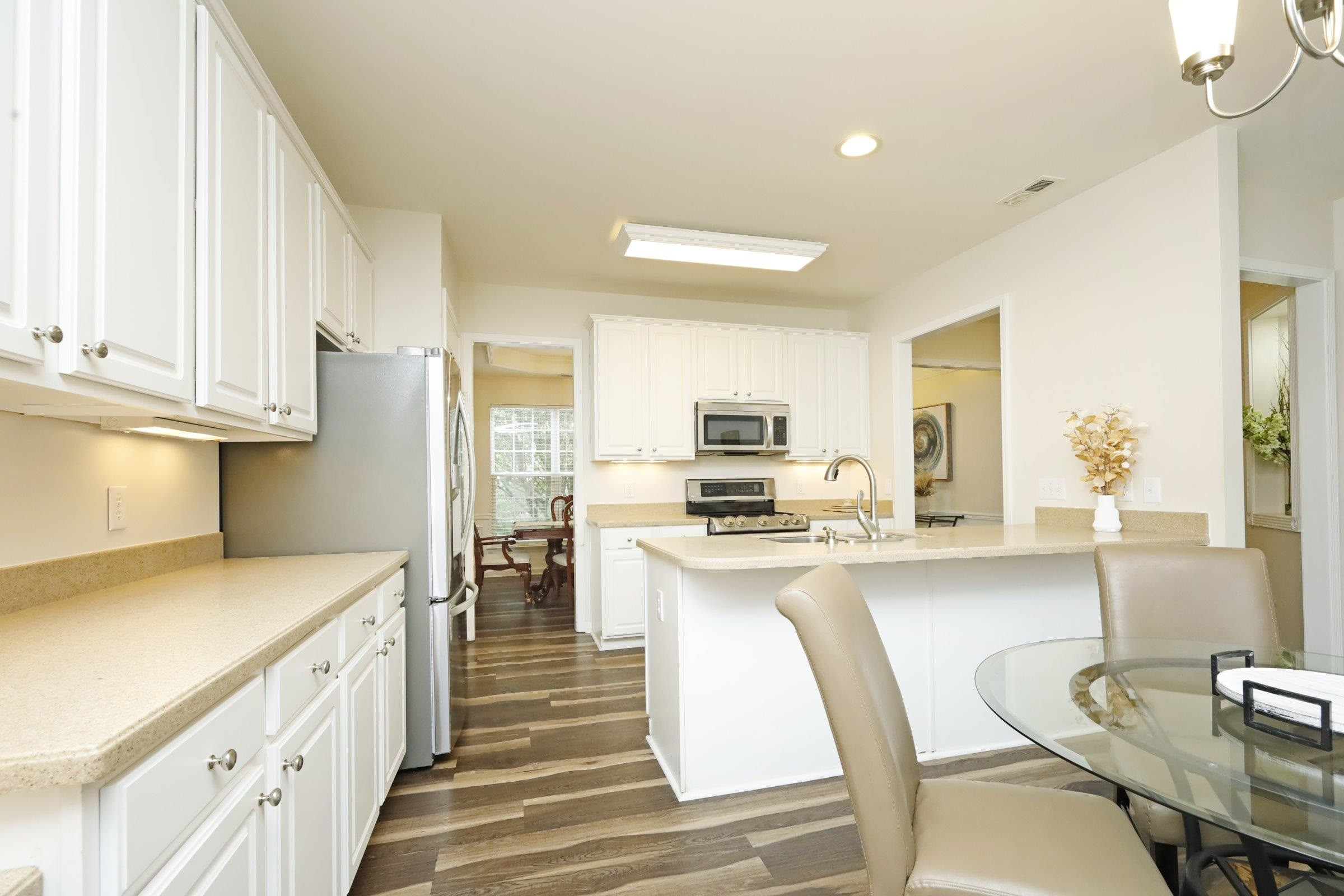 5313 Brandy Bay Road Raleigh, NC 27613 - Photo 9 of 42 a kitchen with stainless steel appliances a stove a sink a oven a dining table and chairs