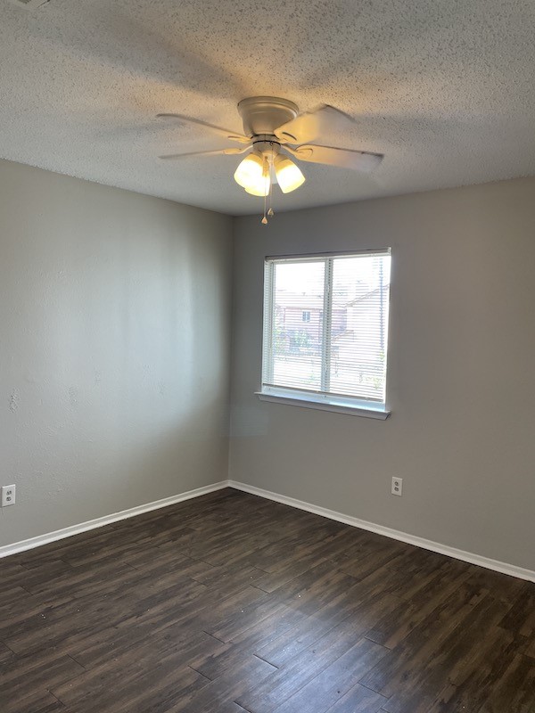 8401 Colony Loop Drive, Unit D Austin, TX 78724 - Photo 14 of 18 a view of an empty room with wooden floor and a window