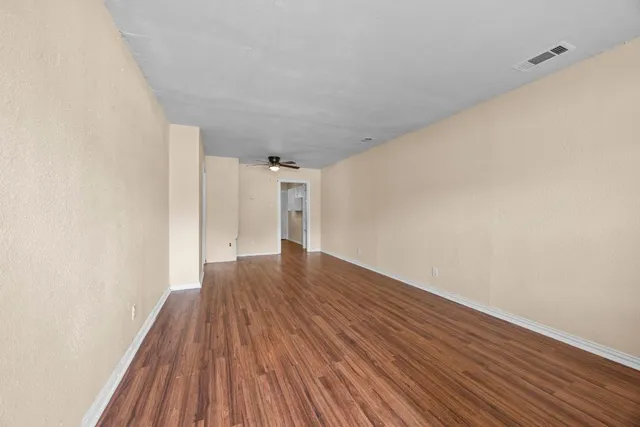 a view of a room with wooden floor and white walls