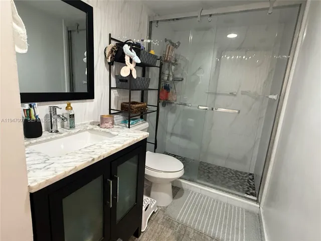 a bathroom with a sink a toilet and shower