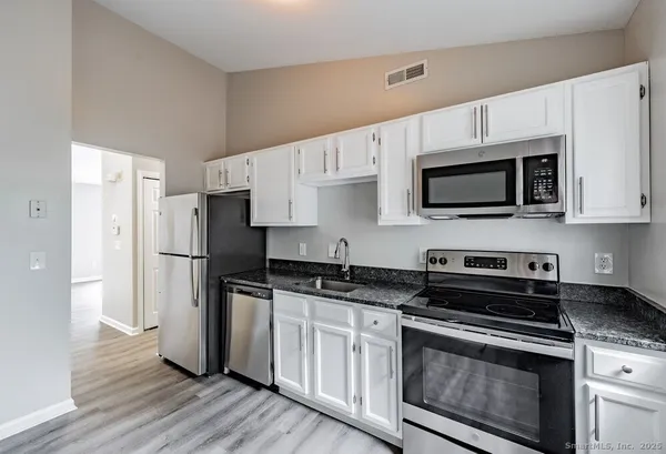 a kitchen with stainless steel appliances a stove microwave and a refrigerator