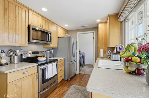 a kitchen with stainless steel appliances a stove a sink cabinets and a refrigerator