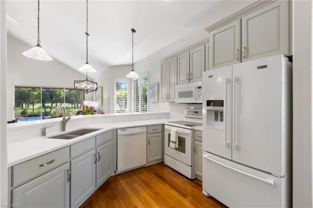 a kitchen with white cabinets and white appliances