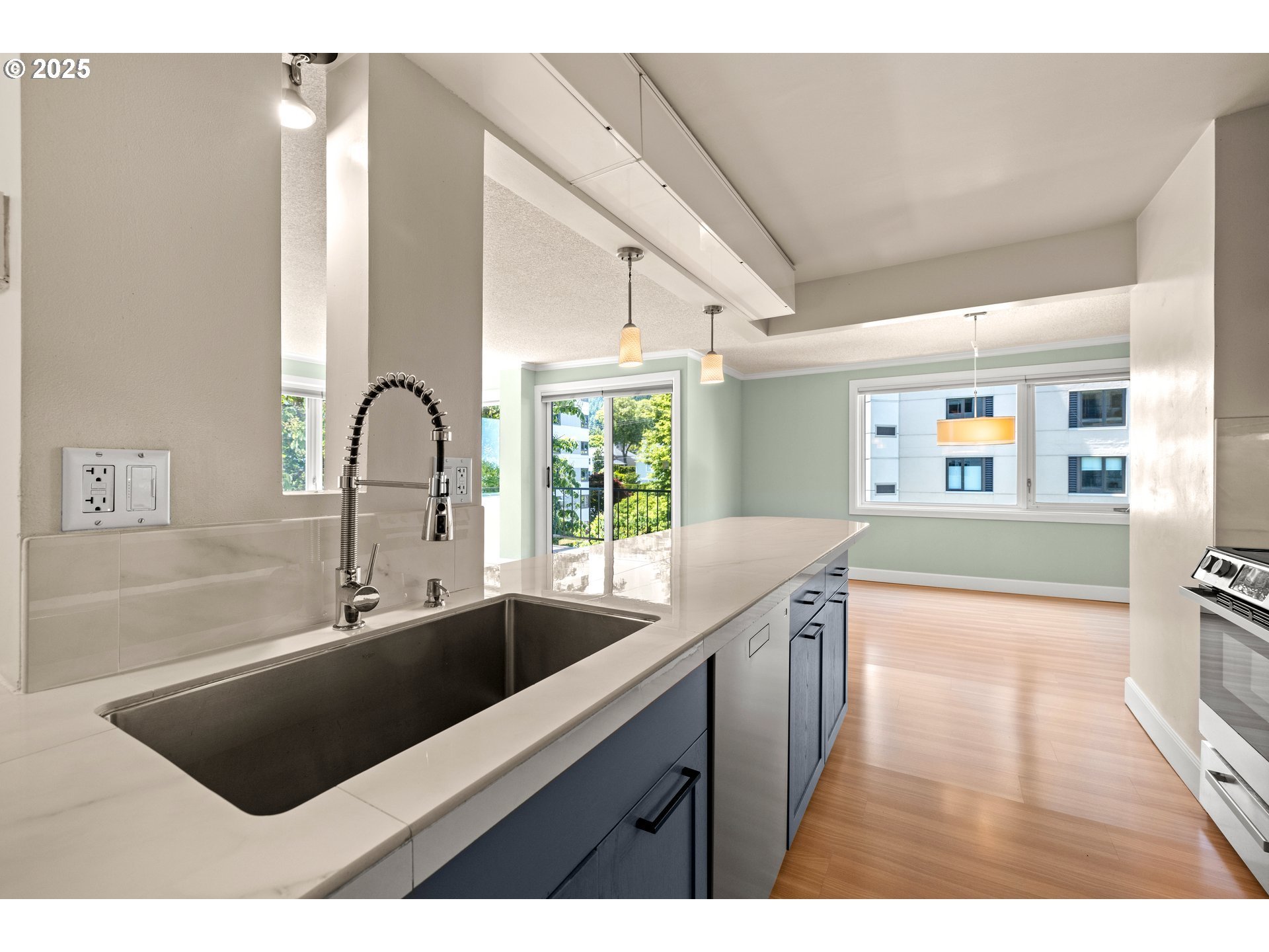 2211 Southwest Park Place, Unit 603 Portland, OR 97205 - Photo 15 of 27 a kitchen with stainless steel appliances granite countertop a sink and a wooden floors