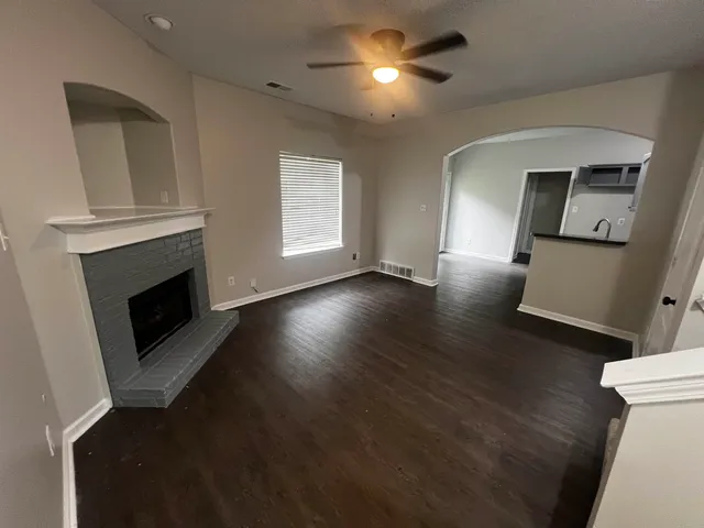 a view of a livingroom with wooden floor a fireplace and window