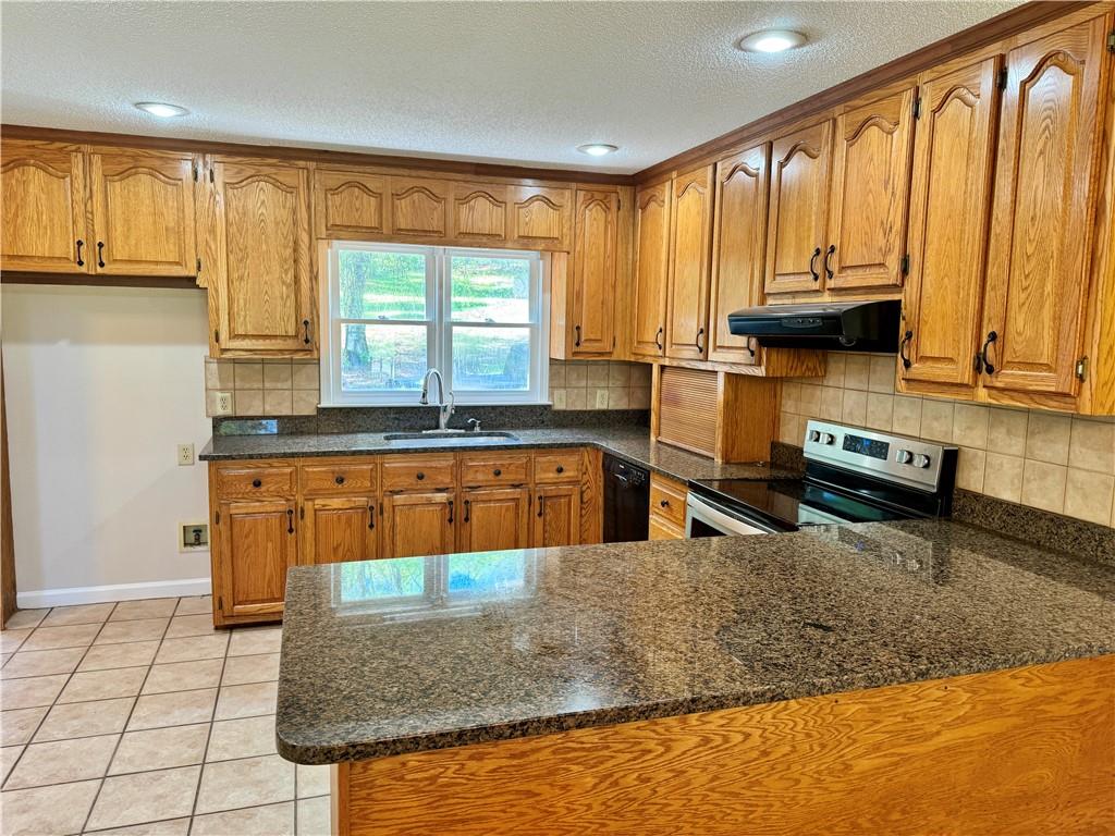 999 Grassdale Road Northwest Cartersville, GA 30121 - Photo 20 of 54 a kitchen with stainless steel appliances granite countertop a stove a sink and a microwave
