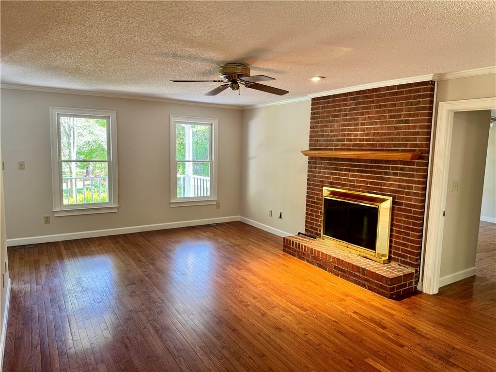 999 Grassdale Road Northwest Cartersville, GA 30121 - Photo 10 of 54 a view of an empty room with wooden floor fireplace and a window