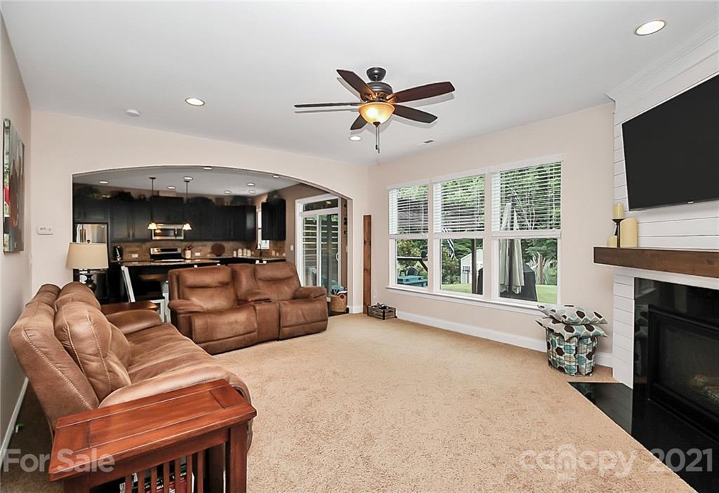 6012 Fallondale Road Waxhaw, NC 28173 - Photo 14 of 45 a living room with furniture a fireplace and a flat screen tv