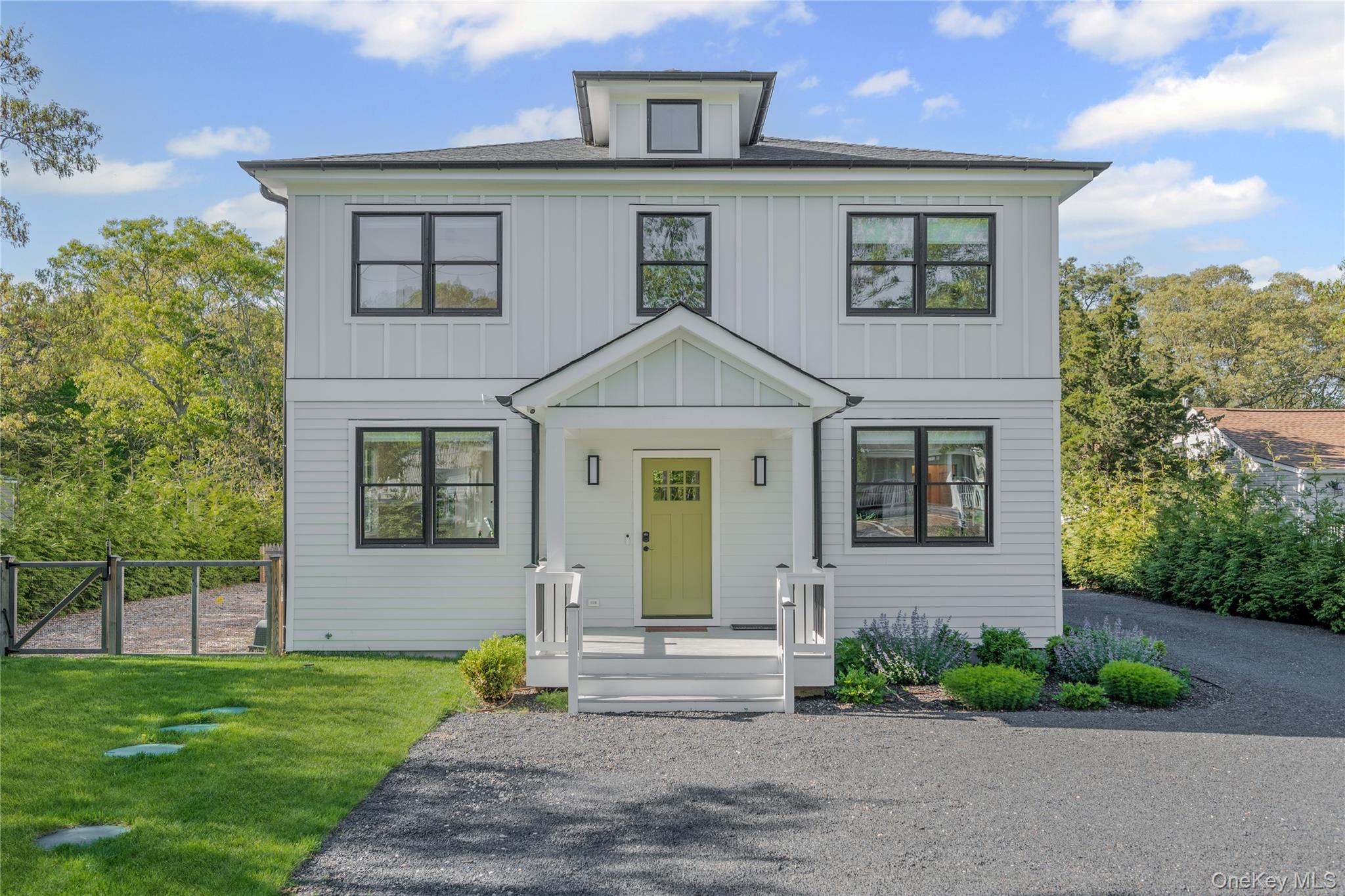 a front view of a house with a garden and yard