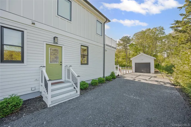a front view of a house with a garden and trees