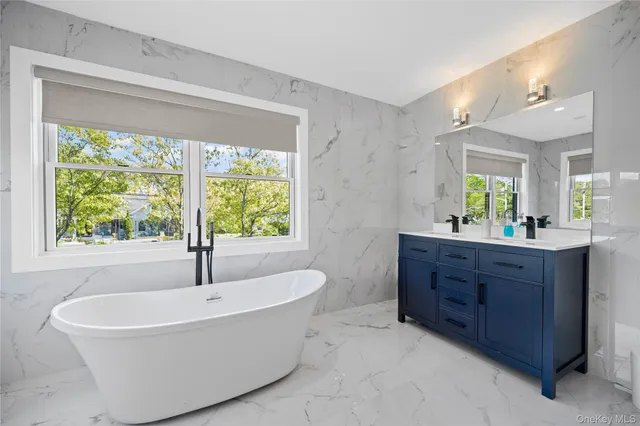 a bathroom with a tub sink and mirror