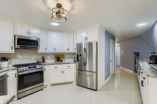 a kitchen with stainless steel appliances a refrigerator sink and microwave