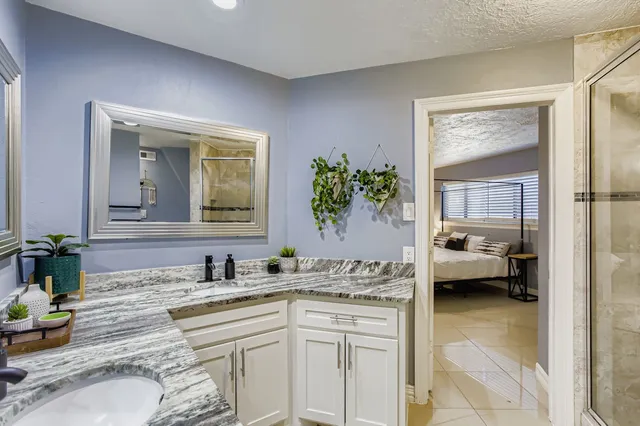 a spacious bathroom with a granite countertop sink toilet and shower