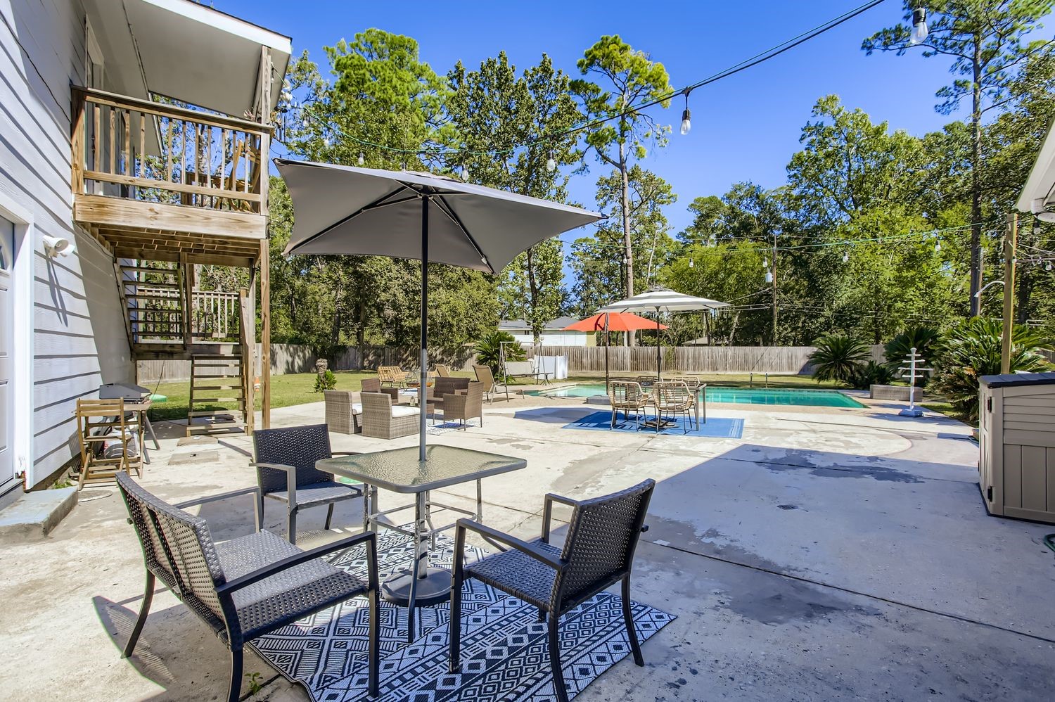 16614 Creeksouth Road Houston, TX 77068 - Photo 30 of 36 a patio with a table and chairs under an umbrella