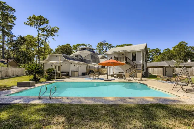 a view of a house with swimming pool and a yard