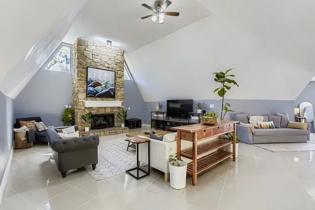 a living room with furniture a fireplace and a flat screen tv