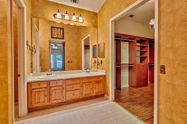 a bathroom with a tub a sink and a large mirror