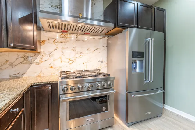 a metallic refrigerator freezer sitting inside of a kitchen
