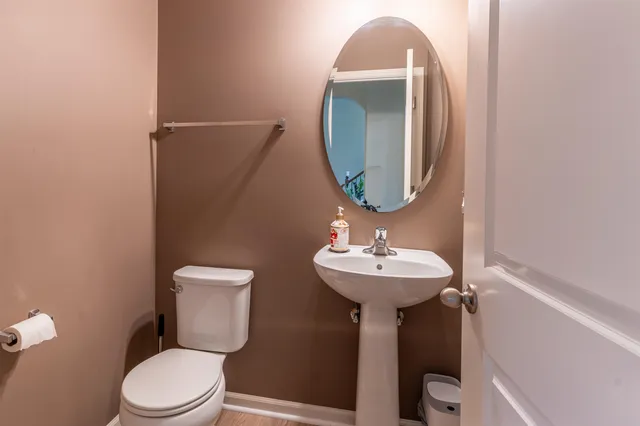 a bathroom with a toilet sink and mirror
