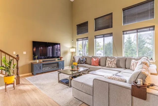 a living room with furniture a flat screen tv and a large window