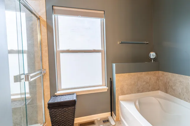 a bathroom with bathtub and window