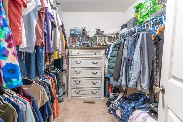 a view of walk in closet with clothes and shoes