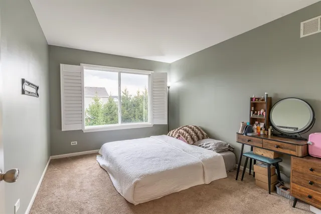 a bedroom with a bed a mirror and a window