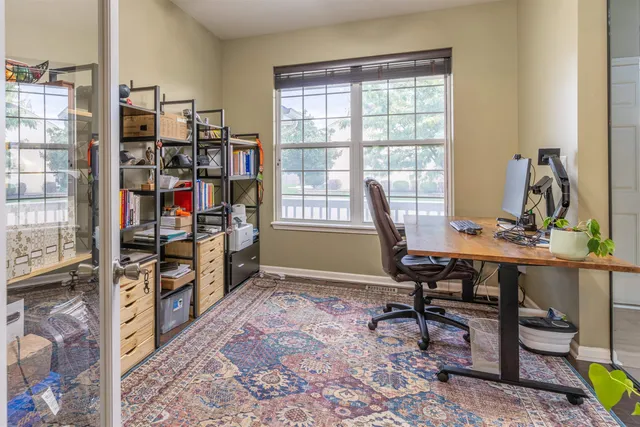 a view of a workspace with furniture and a window