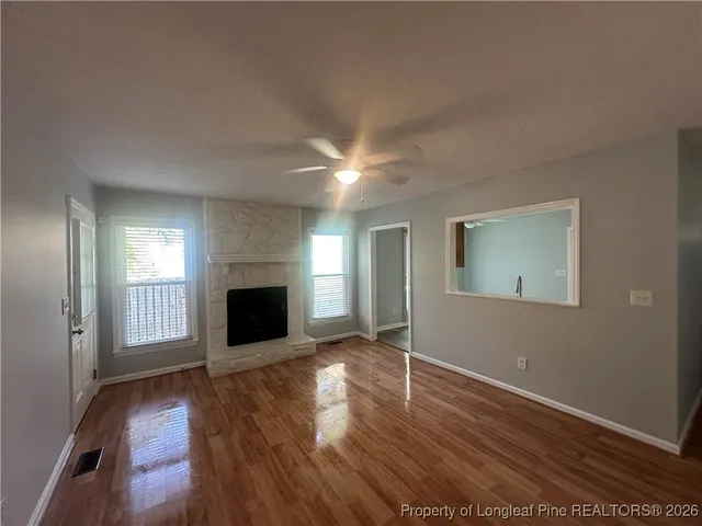an empty room with wooden floor and fireplace