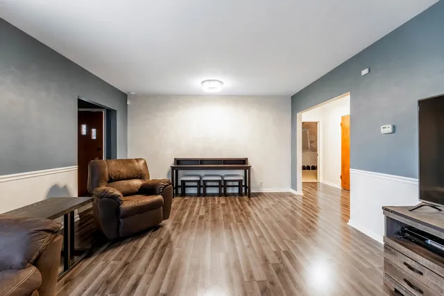 a living room with furniture and a wooden floor