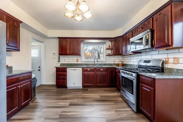 a kitchen with stainless steel appliances granite countertop a stove sink and cabinets