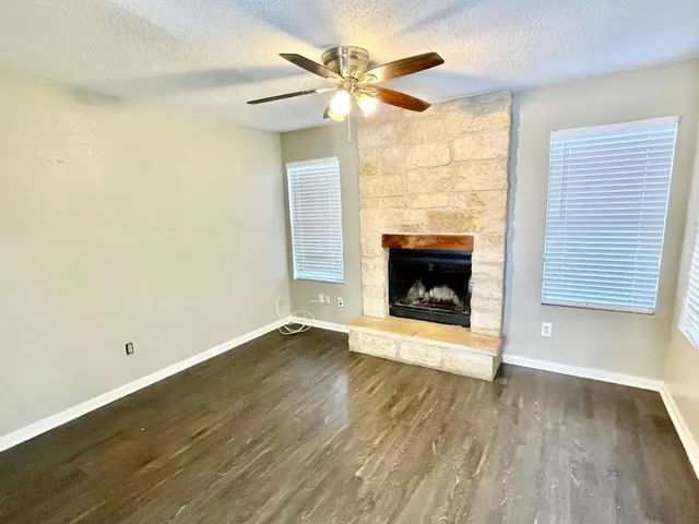 an empty room with a fireplace and wooden floor