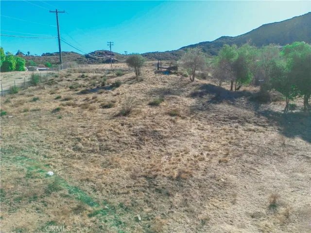 a view of a dry yard with mountains in the background