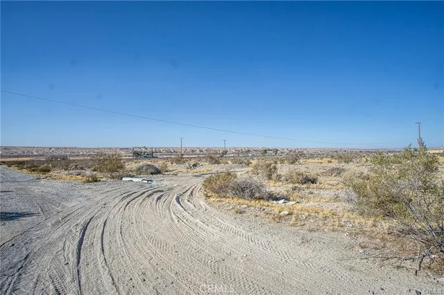 a view of a dry yard with wooden fence