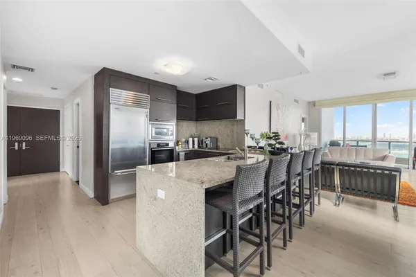 a kitchen with refrigerator and chairs