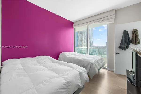 a bedroom with a bed and a flat screen tv