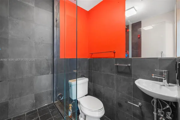 a bathroom with a toilet a sink and mirror