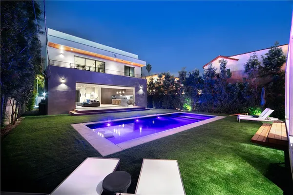 a view of swimming pool with lawn chairs and a yard